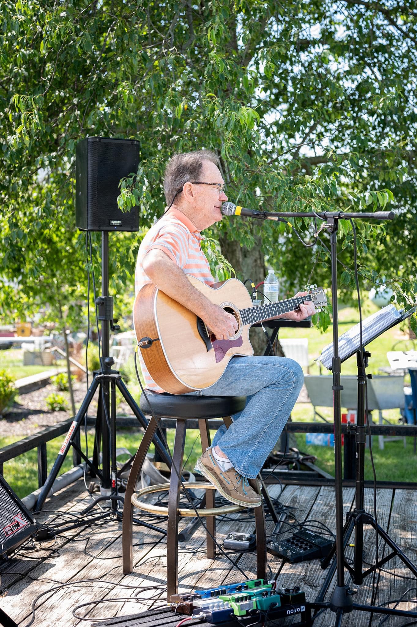 man singing on outdoor stage at event venue