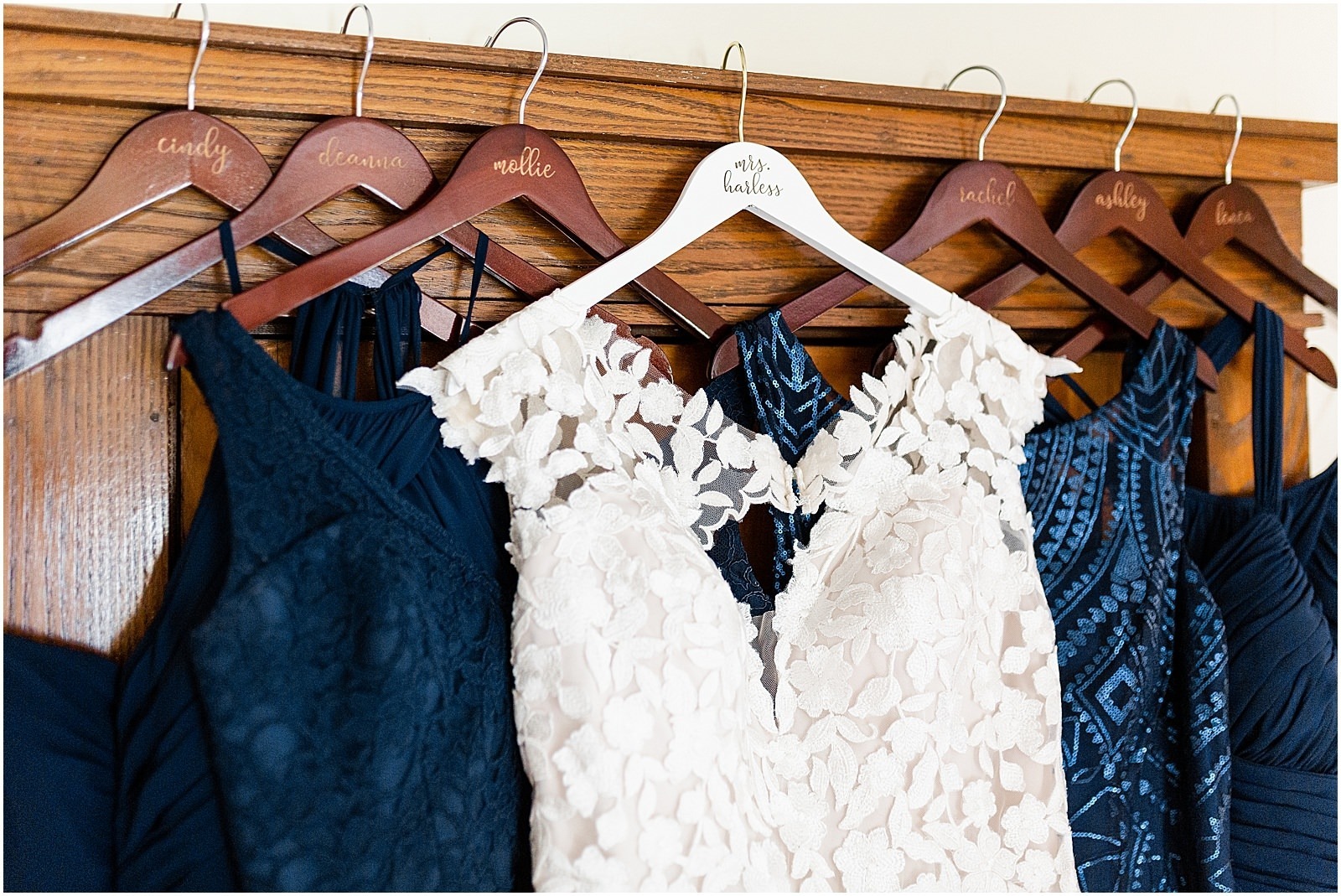 bridal gown hanging with navy blue bridesmaids dresses