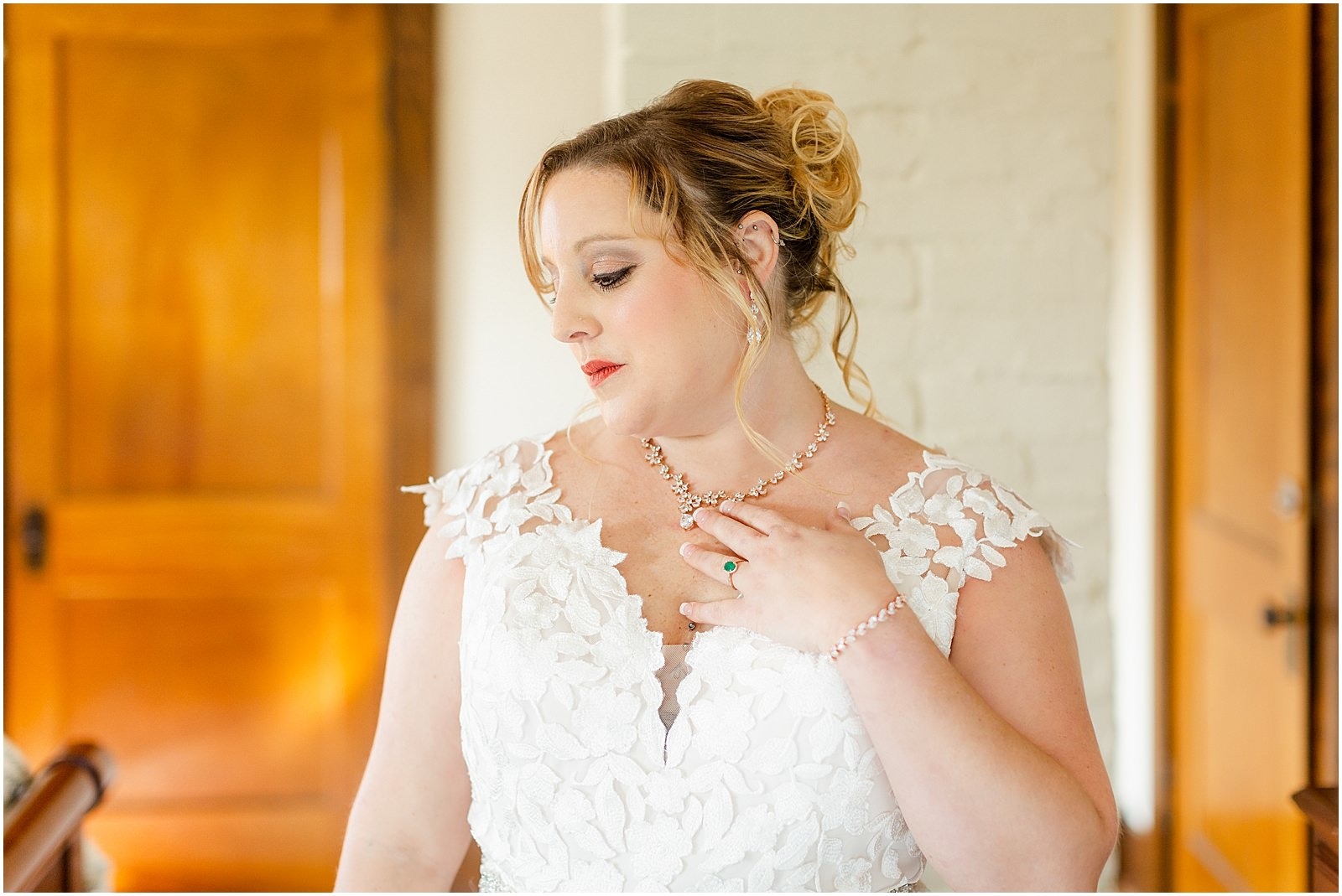 bride in floral applique gown with emerald engagement ring