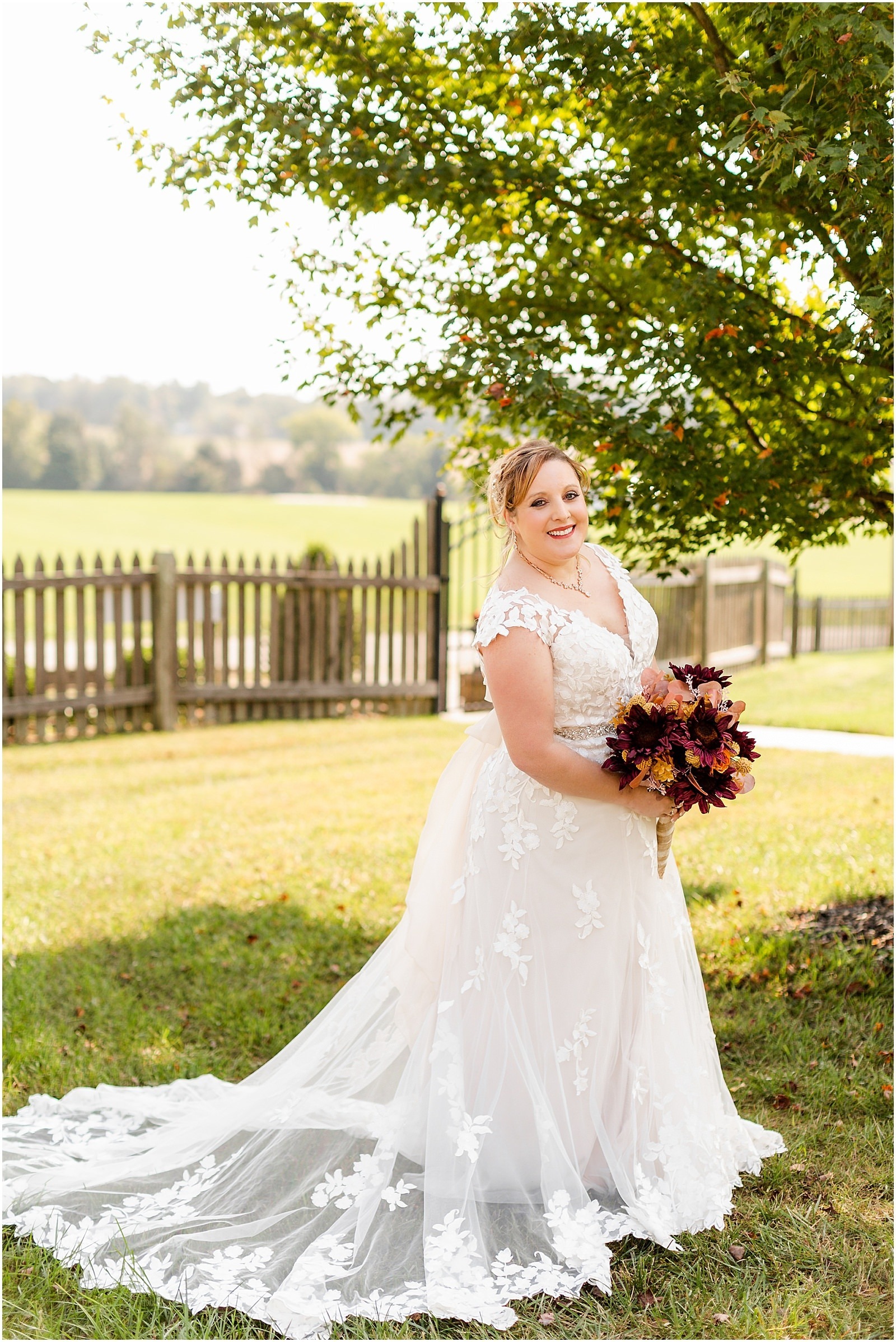 bride smiling with green trees and pasture in the background