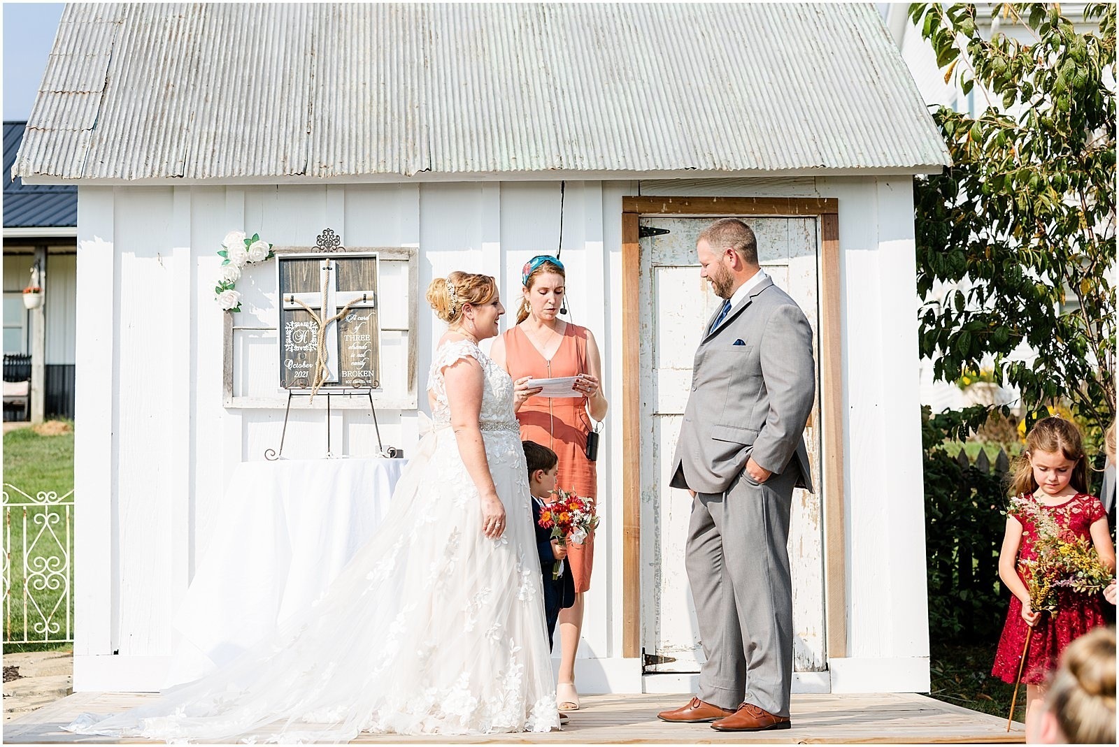 bride and groom saying vows in front of vintage farmhouse