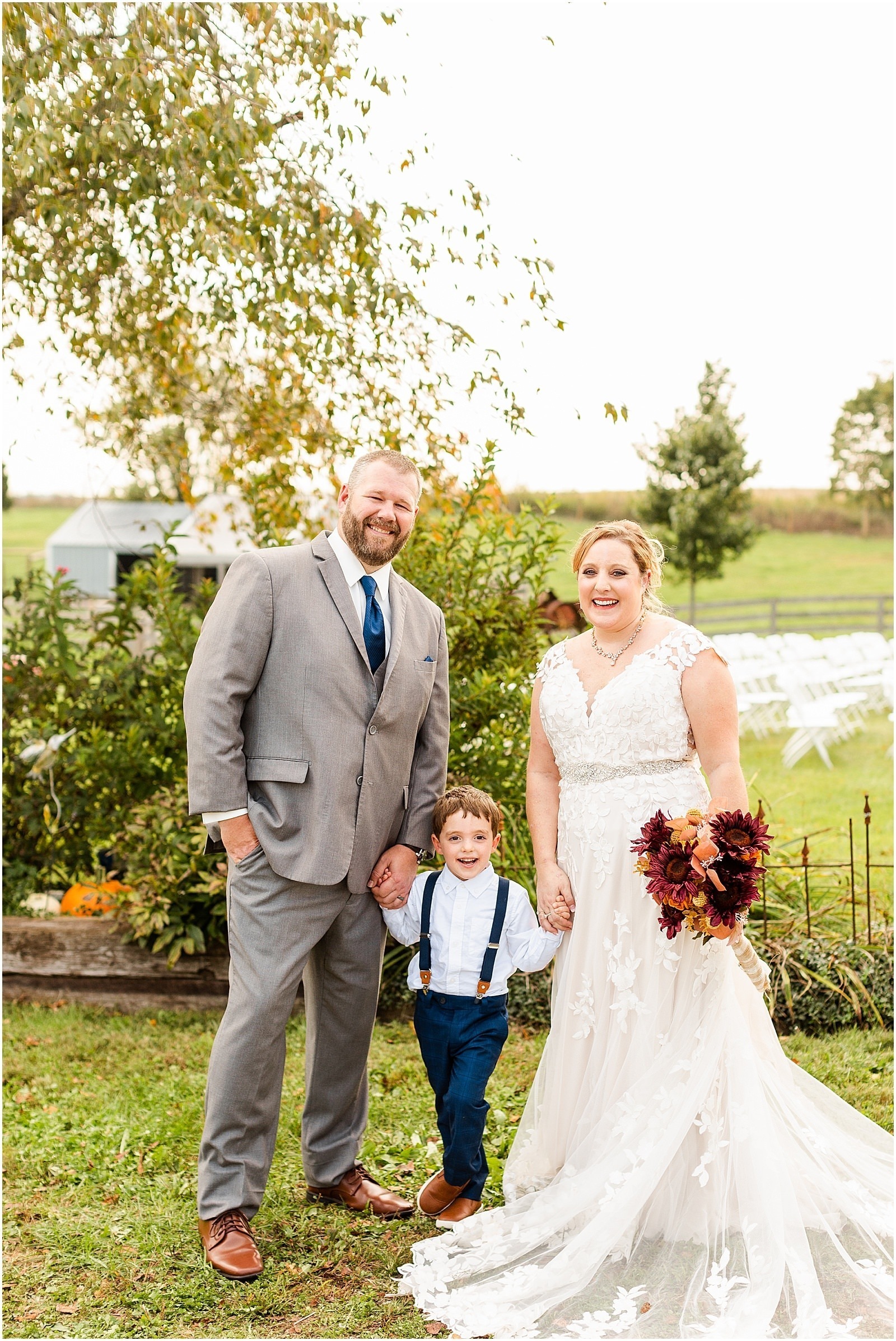 bride and groom smiling and holding hands with son